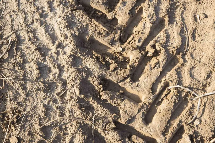 Die Spur eines Traktorreifens im Ackerboden