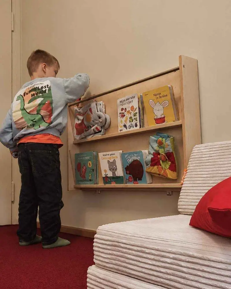 Ein Kind blättert in einem Bücherregal