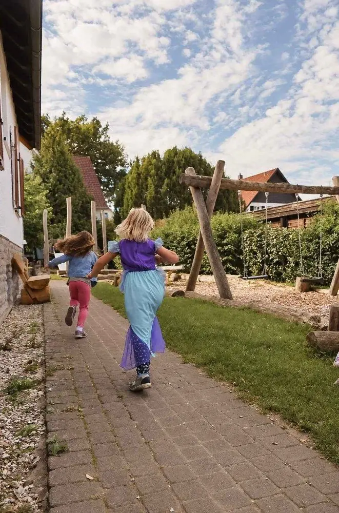 Zwei Kinder rennen über den Gartenweg