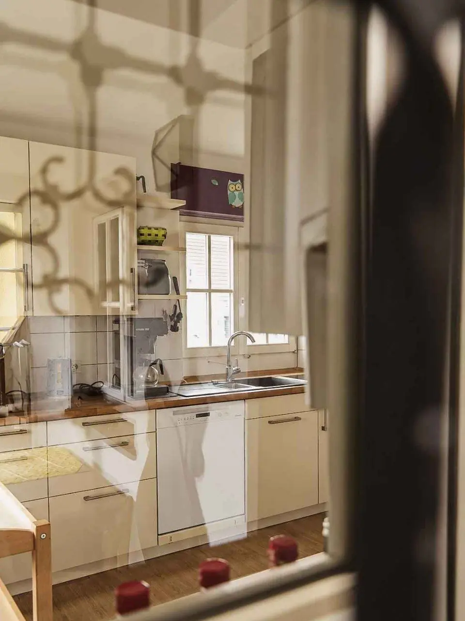 Blick in die helle Küche der Villa durch eine Glasscheibe